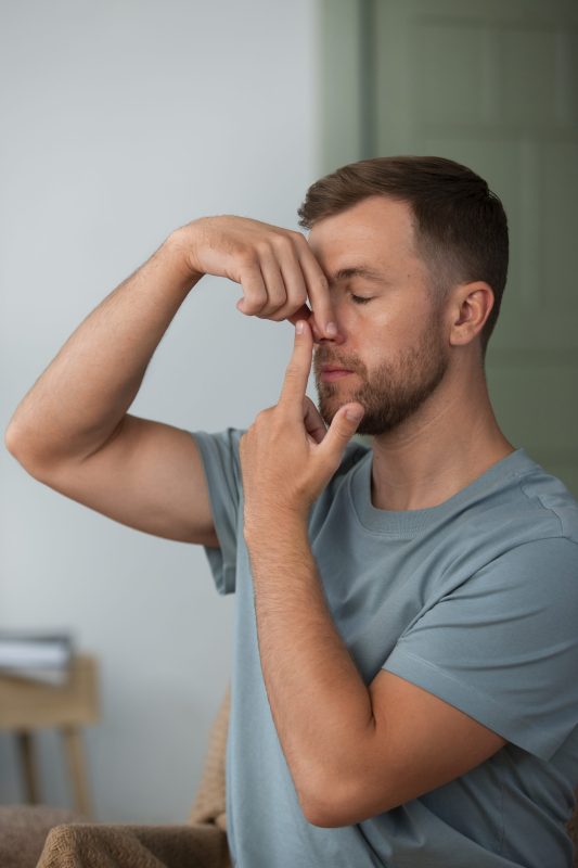 Bărbat practicând tehnica de respirație Nadi Shodhana Pranayama. Respirație alternativă pe nări. Yoga. Bărbat practicând tehnica de respirație Nadi Shodhana Pranayama. Respirație alternativă pe nări. Yoga.
