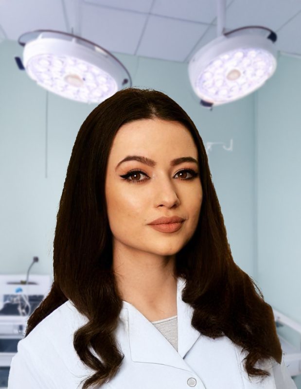 Medic specialist în halat alb, într-o sală de operație cu lumini chirurgicale.